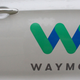 A photo of a Waymo logo on a car door.